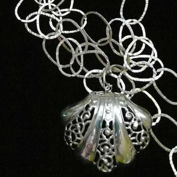 This large openwork scalloped seashell makes a beautiful choker...or, wear it as a single charm on a linked bracelet... for an eye-catching piece of whimsy.  Sterling Silverr Clam on the Half Shell Charm. Handmade in America with love, and hand-sgned. Accompanied by a long leather cord or vintage inspired ribbon. 2-1/2" x 2-1/4" Also available as shoe clip.