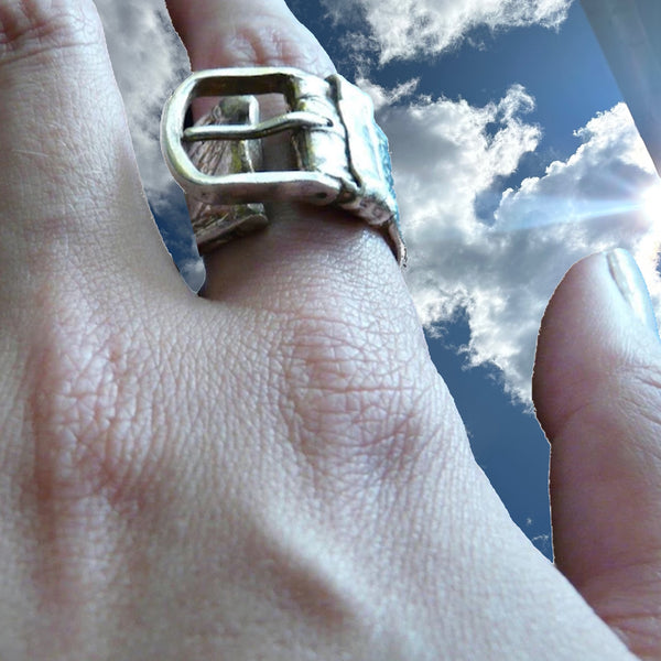 Substantial piece of pure vintage rock and roll--as seen on Zane Carney, in Avril Lavigne's "I Fell in Love with the Devil"Music Video.. Opulent,finely detailed band of timeless whimsy in Oxidized Sterling Silver Buckle Ring makes a statement alone or as part of a collection of fables...Sterling Silver distressed Crocodile textured buckle ring. Handmade in America and Hand-signed.  Edit alt text