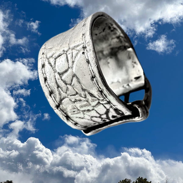 Substantial piece of pure vintage rock and roll--as seen on Zane Carney, in Avril Lavigne's "I Fell in Love with the Devil"Music Video.. Opulent,finely detailed band of timeless whimsy in Oxidized Sterling Silver Buckle Ring makes a statement alone or as part of a collection of fables...Sterling Silver distressed Crocodile textured buckle ring. Handmade in America and Hand-signed.  Edit alt text